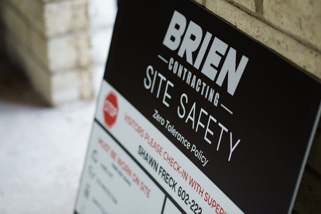 A construction site safety sign for Brien Contracting, highlighting a zero tolerance policy and contact info. Reminds workers: Why Clean Job Sites Save Lives - and Money.