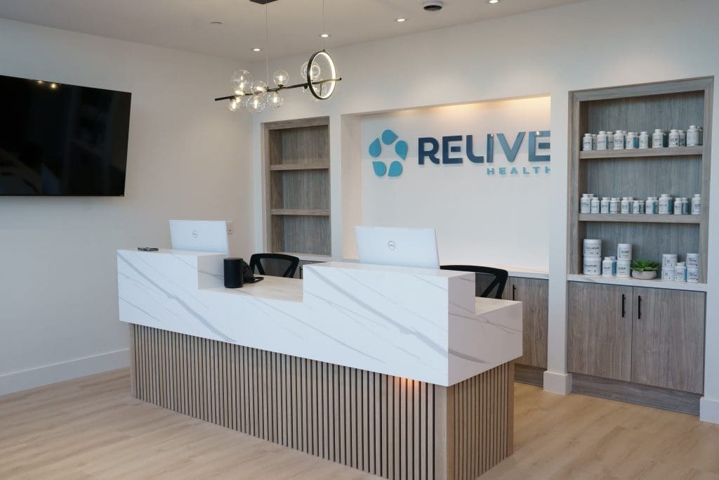 White quartz countertops over wood tambour detail with retail fixtures, signage and unique lighting.