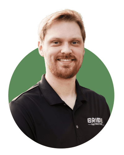 Headshot photo of Project Manager Adam with Brien Contracting. He is wearing a black polo shirt and has facial hair.